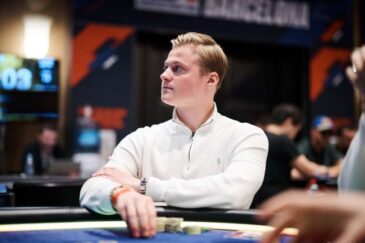 Casimir Seire istuu pokeripöydässä. Hän katsoo sivulle ja pitää kädessään pelimerkkejä. Seirellä on päällään valkoinen paita.