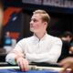 Casimir Seire istuu pokeripöydässä. Hän katsoo sivulle ja pitää kädessään pelimerkkejä. Seirellä on päällään valkoinen paita.