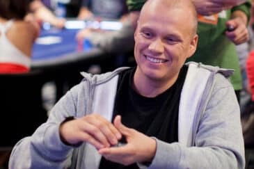 Ilari Sahamies istuu pokeripöydässä harmaassa hupparissa