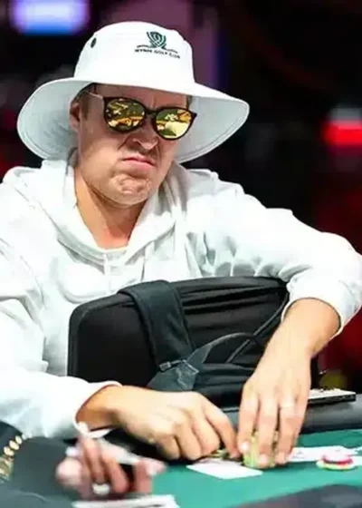 Eelis Pärssinen istuu pokeripöydässä. Hänellä on päässään valkoinen lierihattu. Silmillään Pärssisellä on tummat peililasit.