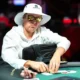 Eelis Pärssinen istuu pokeripöydässä. Hänellä on päässään valkoinen lierihattu. Silmillään Pärssisellä on tummat peililasit.