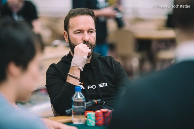 Mietteliään näköinen mies istuu pokeripöydän ääressä. Edessään miehellä on pino pelimerkkejä. Miehellä on musta paita.