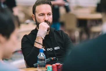 Mietteliään näköinen mies istuu pokeripöydän ääressä. Edessään miehellä on pino pelimerkkejä. Miehellä on musta paita.