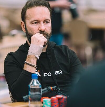 Mietteliään näköinen mies istuu pokeripöydän ääressä. Edessään miehellä on pino pelimerkkejä. Miehellä on musta paita.