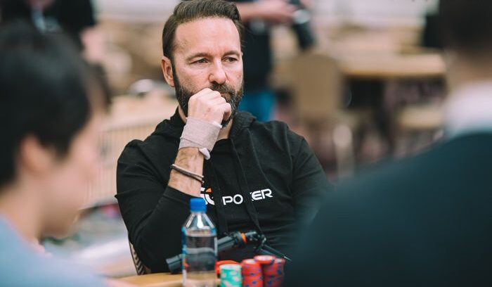 Mietteliään näköinen mies istuu pokeripöydän ääressä. Edessään miehellä on pino pelimerkkejä. Miehellä on musta paita.