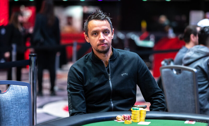Tero Laurila istuu pokeripöydässä edessään erivärisiä pelimerkkejä. Hänellä on yllään pitkähihainen paita, jossa on vetoketju.