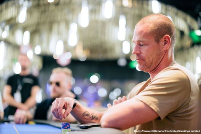 Patrik Antonius istuu pokeripöydässä kauniisti valaistussa pelisalissa