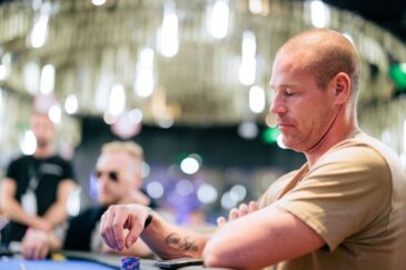 Patrik Antonius istuu pokeripöydässä kauniisti valaistussa pelisalissa