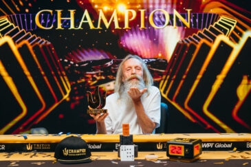 Vladimir ”Joulupukki” Korzinin poseeraa Monte Carlon pokeriturnauksen voittajakuvassa. Hän lähettää kameralle lentosuukon.
