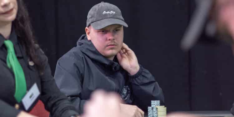 Elias Suhonen istuu mietteliäänä pokeripöydässä. Hän nojaa vasemmalla kädellään leukaan.Hänellä on päässään musta lippis.