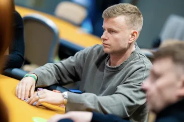 Jens Kyllönen istuu pokeripöydässä Tallinnan Chesterfield Poker Clubilla. Kyllösellä on vakava ilme kasvoillaan ja harmaa huppari