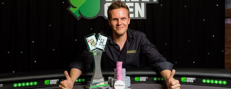 Joni Liimatta istuu tyytyväisenä vuoden 2016 Unibet Open Kööpenhamina pokeriturnauksen voittajakuvassa. Hänen edessä on pokaali