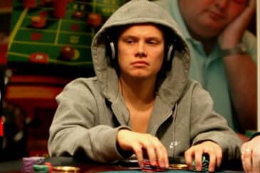 Ilari Sahamies istuu pokeripöydän ääressä vihreä huppu päässään ja kuulokkeet korvillaan