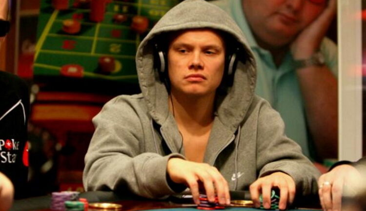Ilari Sahamies istuu pokeripöydän ääressä vihreä huppu päässään ja kuulokkeet korvillaan
