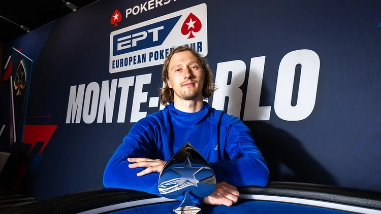 Aku Joentausta istuu Monte Carlon EPT -voittajakuvassa. Hänellä on päällään sininen paita ja edessään hopeinen voittopokaali.
