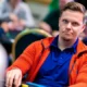 Joni Liimatta istuu pokeripöydässä. Hänellä on edessään pelimerkkejä. Jonilla on päällään punainen huppari, jonka alla t-paita