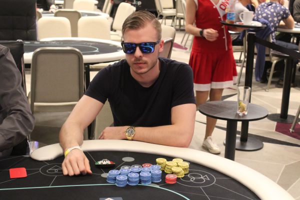 Pauli "Fiilismies" Äyräs istuu pokeripöydässä Tallinnassa. Hänellä on mustat aurinkolasit päässä ja musta t-paita päällänsä.
