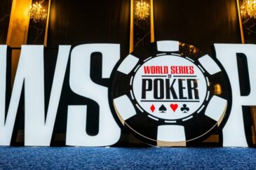Etualalla World Series of Poker logo. Logo on sinisen alustan päällä. Taustalla on tummaa seinää. Tilaa valaisee seinävalot.