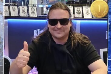 Pitkähiuksinen mies istuu pokeripöydässä. Hänellä on päällään musta t-paita sekä mustat aurinkolasit. Hän näyttää myös peukkua.