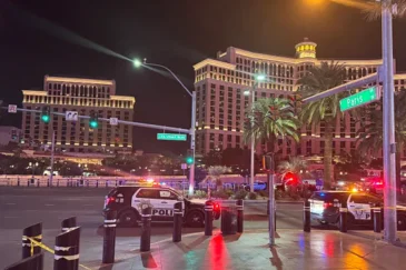 Las Vegasin Strip, jossa on poliisiautoja. Tien vieressä on palmuja. Takana näkyy Bellagion Hotelli ja kuuluisat suihkulähteet.