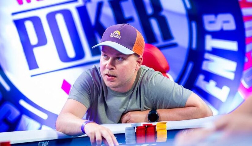 Mathias Siljander istuu pokeripöydässä. Hänellä on päässään lippalakki. Miehen edessä pöydällä on neljä tornia erivärisiä pelimerkkejä.