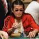 Scotty Nguyen istuu pokeripöydän ääressä punaisessa takissa ja aurinkolasit päässään edessään merkkipino