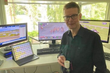 Jorma Vuoksenmaa kotitoimistollaan kahvikuppi kädessä mustassa kauluspaidassa.