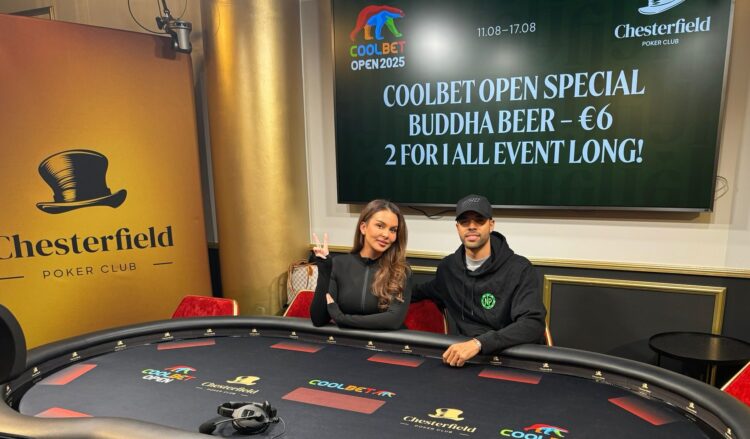 Nainen ja mies istuvat pokeripöydän ääressä, taustalla on televisio näyttö ja valkoista ja keltaista