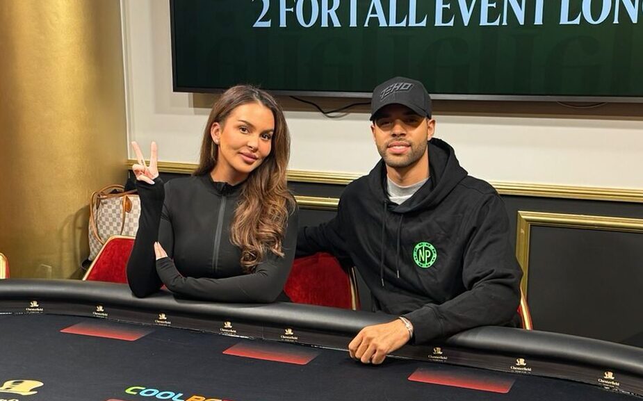 Nainen ja mies istuvat pokeripöydän ääressä, taustalla on televisio näyttö ja valkoista ja keltaista