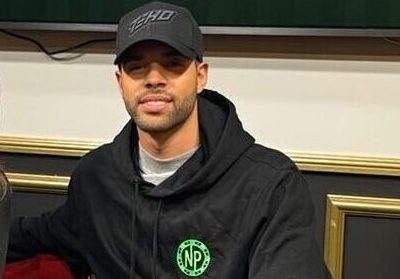 Nainen ja mies istuvat pokeripöydän ääressä, taustalla on televisio näyttö ja valkoista ja keltaista