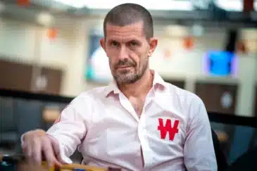 Gus Hansen istuu pinkissä paidassa pöydän ääressä