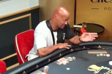 Jussi Helström pokeripöydän ääressä punaisella tuolilla kädet ojossa