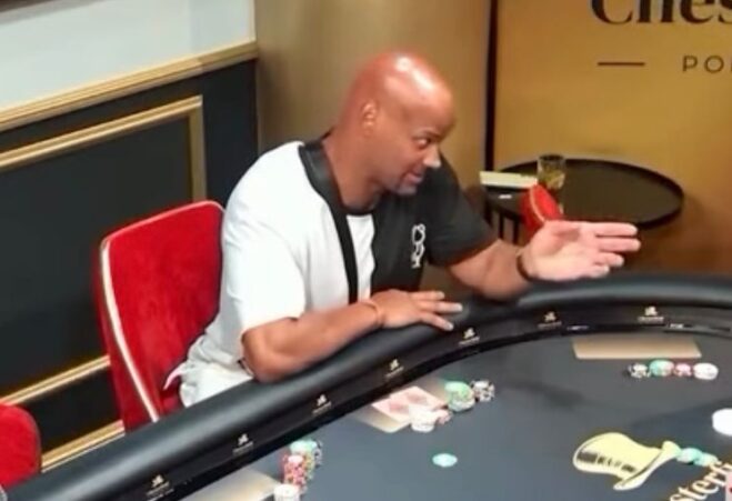 Jussi Helström pokeripöydän ääressä punaisella tuolilla kädet ojossa