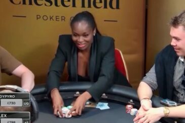 Kelly Kalonji istuu pokeripöydän ääressä musta jakkupuku päällä ja asettaa pelimerkkejä keskemmälle pöytää