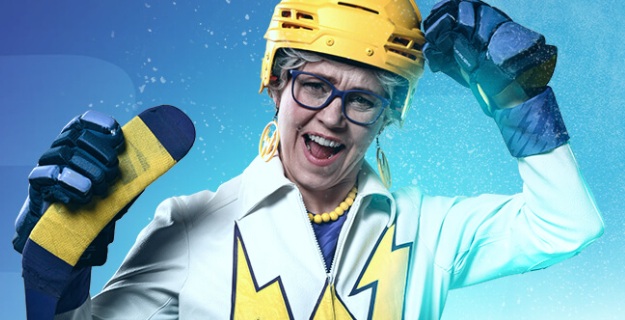 Naisella on päällään valkoinen puku, jossa on keltaista kuviota. Päässään hänellä on keltainen jääkiekkokypärä ja kädessä maila.