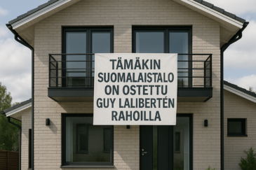 Kuvassa on valkoinen kaksikerroksinen talo, josta roikkuu valkoinen liina. Liinassa on mustaa tekstiä, taivaalla on pilviä.