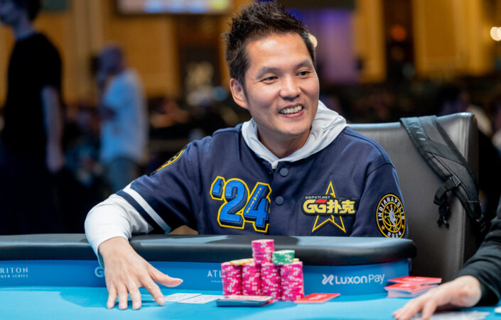 Kiinalainen pokerinpelaaja Ren Lin istuu pokeripöydän ääressä huppari päällään ja pelimerkkejä edessään