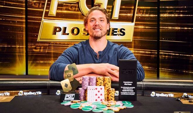 Alex Foxen istuu pokeripöydässä. Miehellä on päällään sininen paita, josta on hihat kääritty. Miehen edessä on pelimerkkejä ja kortteja.