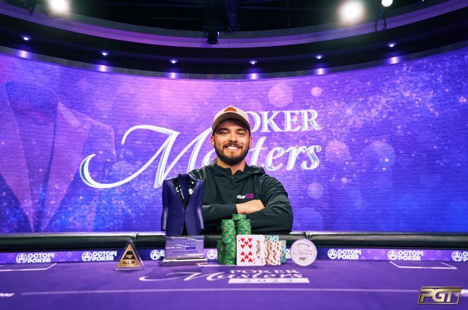Kuvassa on onnellinen mies, joka juhlii voittoaan arvostetussa Poker Masters -pokeriturnauksessa. Hän poseeraa leveästi hymyillen violetin pelipöydän takana, ja hänen edessään on suuri pino pelimerkkejä sekä voittokäsi (hertta 7 ja 9). Pöydällä on myös turnauksen ikoninen pääpalkinto – purppuranvärinen pikkutakki – sekä toinen pokaali. Taustalla loistaa suuri, kimaltavan violetti näyttö, jossa lukee "Poker Masters". Kuvan yleisilme on juhlava ja ammattimainen, ja se vangitsee täydellisesti suuren voiton hetken.