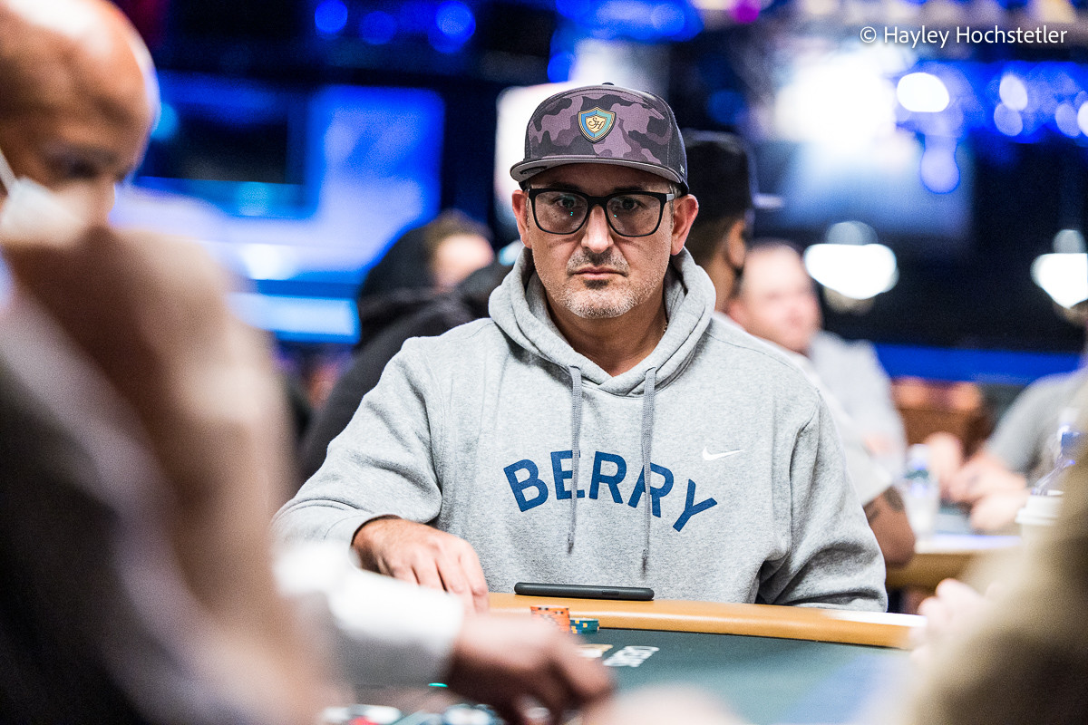 Kuvassa on yhdysvaltalainen huipputason pokeriammattilainen Josh Arieh. Hän on moninkertainen World Series of Poker (WSOP) -rannekkeen voittaja ja ansaitsi arvostetun WSOP Player of the Year -tittelin vuonna 2021. Kuvassa Arieh istuu pokeripöydässä äärimmäisen keskittyneenä ja tuijottaa intensiivisesti eteensä. Hänellä on yllään harmaa "BERRY"-huppari, silmälasit ja takaperin käännetty lippalakki. Taustan kirkkaat siniset valot viestivät suuren luokan turnaustapahtumasta. Kuva vangitsee täydellisesti Ariehin tunnetun, periksiantamattoman ja analyyttisen peli-ilmeen. Valokuvaaja on Hayley Hochstetler.