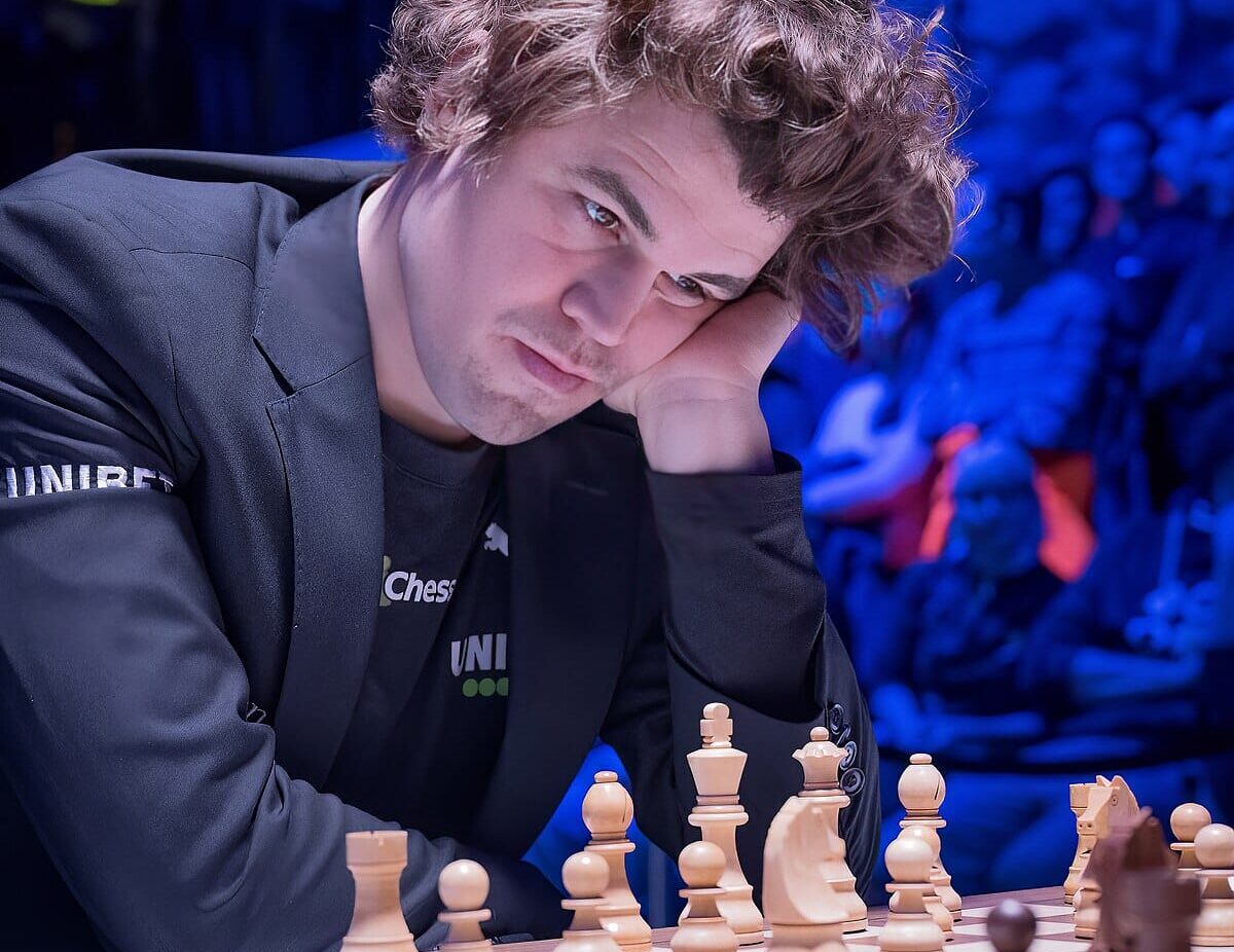 Shakin suurmestari Magnus Carlsen tuijottaa shakkilautaa mietteliäänä