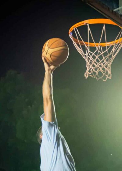 Koripalloa donkataan koriin tummaa taivasta vasten