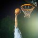 Koripalloa donkataan koriin tummaa taivasta vasten