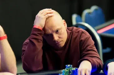 Ilari "Ziigmund" Sahamies istuu pokeripöydässä päällään punainen paita. Hänen ilmeensä on mietteliäs ja hänellä on käsi päälaella.