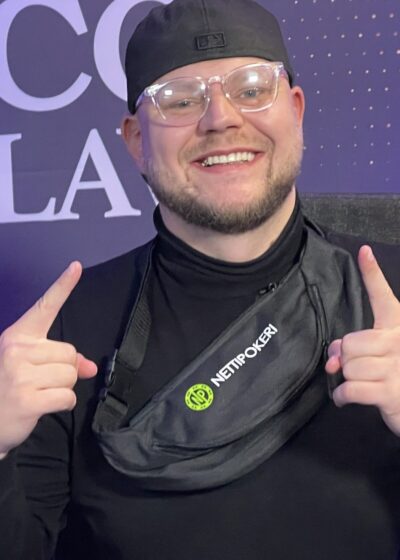 Eetu "Roosteeni" Gråsten humyilee kameralle sormet pystyssä nettipokeri.comin vyölaukku yllään