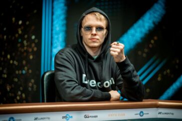 Ossi Ketola istuu pokeripöydässä. Hänellä on päällään tumma huppari. Ketolan vasen käsi on nyrkissä ja yhdessä sormessa on sormus.