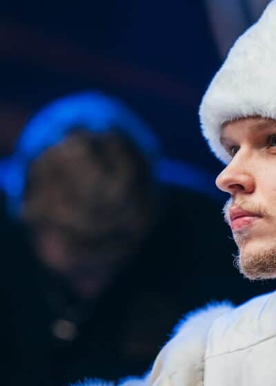 Ossi Ketola istuu valkoinen karvahattu päässään katsoen kaukaisuuteen