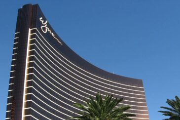 Kasinojätti Wynn kohoaa kuin purjeen muotoisena Las Vegasin sinitaivasta vasten palmujen ympäröimänä