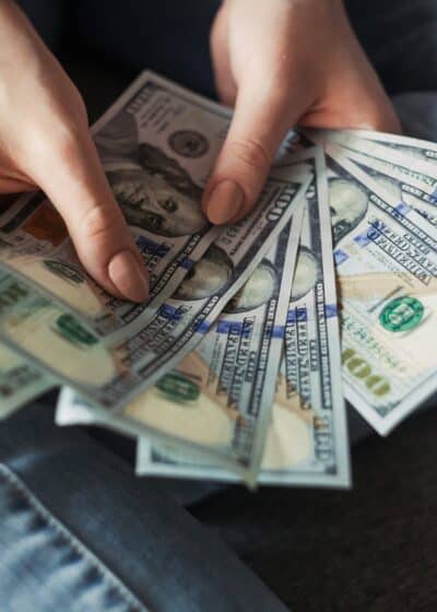 Mies pitelee käsissään levitettyä tukkoa Yhdysvaltojen dollareita