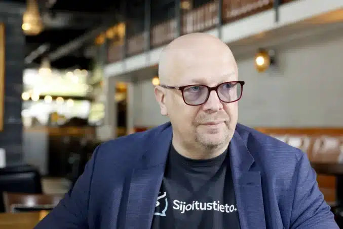 Aki Pyysing istuu vakavana silmälasit päässään